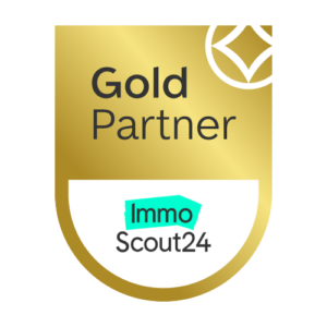 Gold Partner badge for ImmoScout24, featuring a gold shield with a white bottom arc and a turquoise ImmoScout24 label.